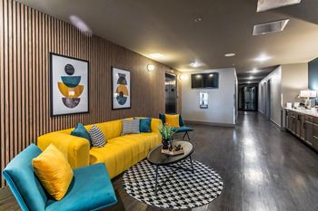 a living room with a yellow couch and blue chairs